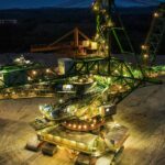 Night view of massive industrial excavator in Bogatynia, Poland.